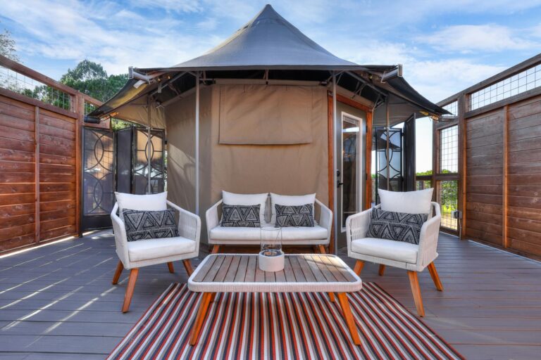 Interior of the Shaka safari tent at Spoon Mountain Glamping, bright white furnishings and light wood