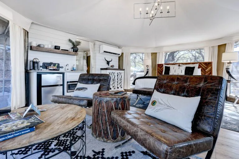 Interior of the Chisum safari tent at Spoon Mountain Glamping, leather furniture and earthy wood tones